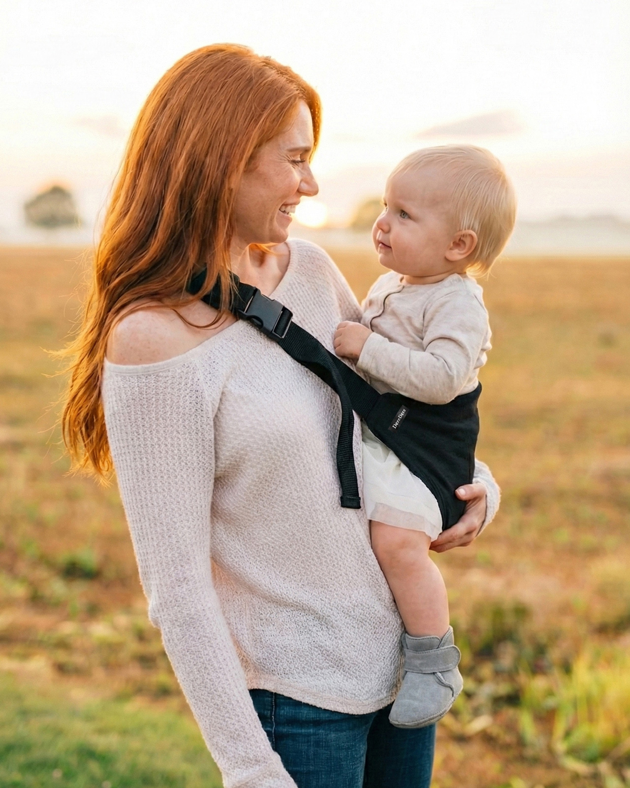 Nosidełko na biodro DereDere mama niesie dziecko na biodrze podczas spaceru w plenerze