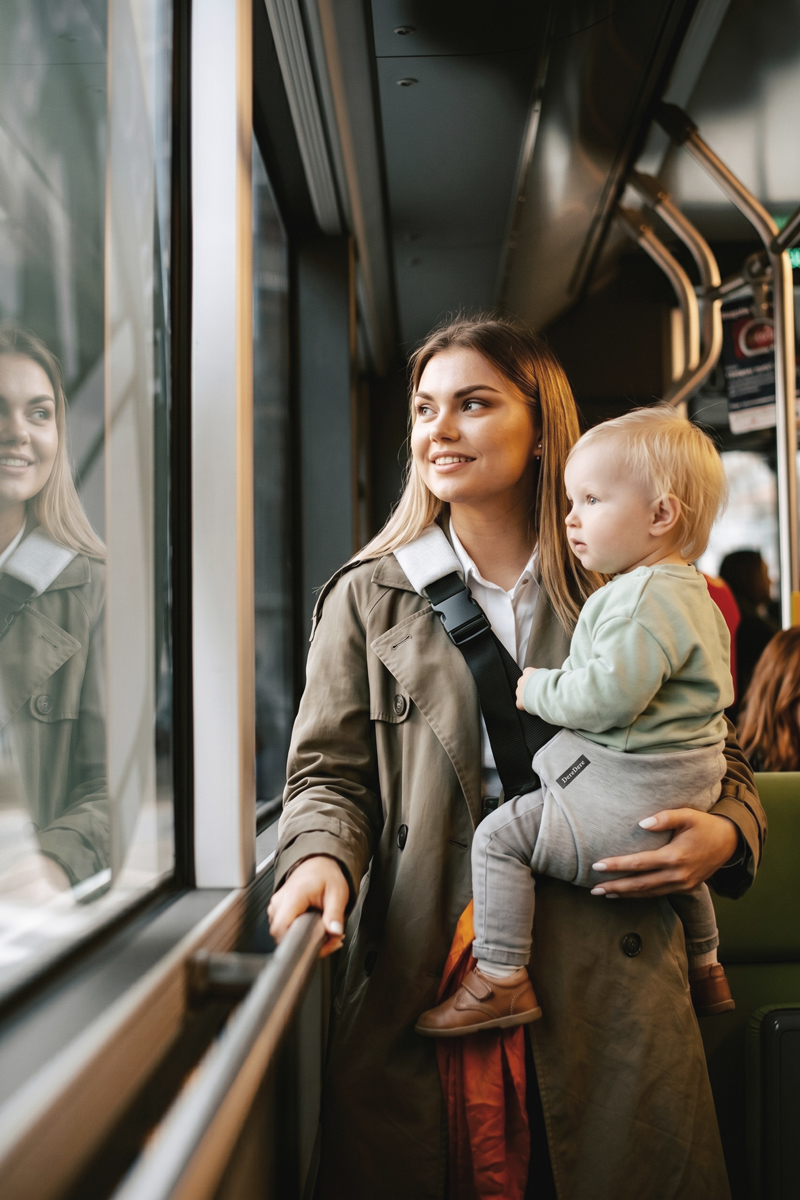 Mama niesie dziecko w nosidełku dla dzieci DereDere w autobusie podczas podróży komunikacją miejską